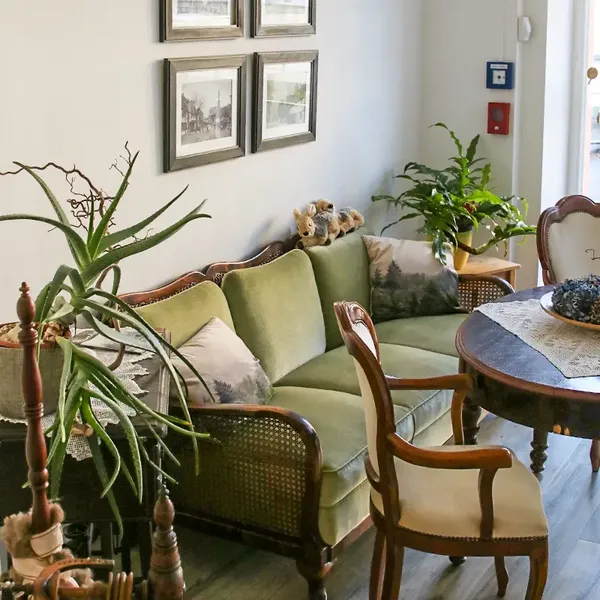 Gemütlicher Sitzbereich mit nostalgischem, grünen Sofa in der Tagespflege "Im Baumhof" in Engelskirchen-Ründeroth